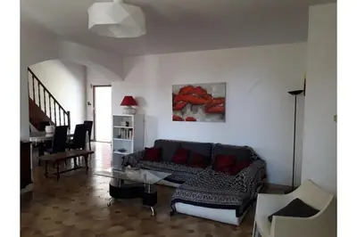 a living room with a couch and a table at Villa climatisée, superbe vue mer in Ventiseri