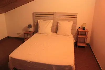 a bedroom with a bed with white sheets and pillows at Villa climatisée, superbe vue mer in Ventiseri