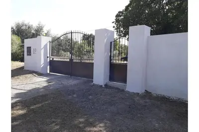 a white fence with a gate in a yard at Villa climatisée, superbe vue mer in Ventiseri