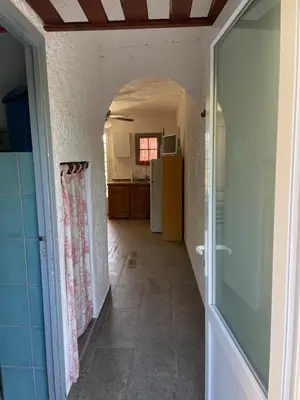 a hallway leading to a kitchen with a refrigerator at LA PALGE Le Centuri in Linguizzetta