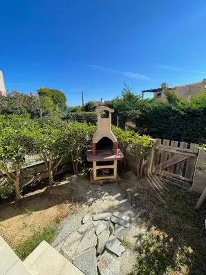 a backyard with an outdoor grill in a yard at LA PALGE Le Centuri in Linguizzetta