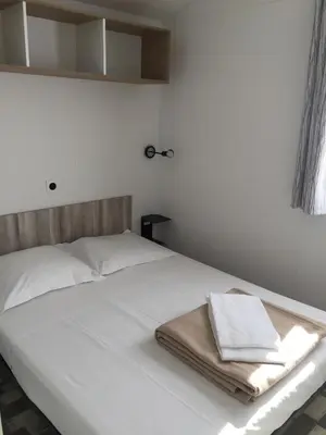 a white bed with two towels on top of it at Camping Milella in Propriano