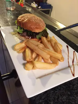 a sandwich and french fries on a white plate at Camping Milella in Propriano