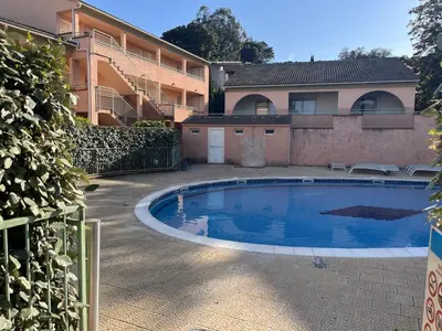 a swimming pool in front of a building at Les jardins de la mer marine de Bravone in Linguizzetta