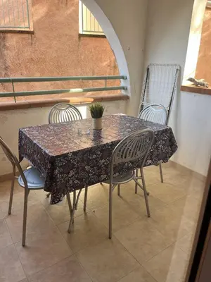 a table with two chairs and a table with a plant on it at Les jardins de la mer marine de Bravone in Linguizzetta