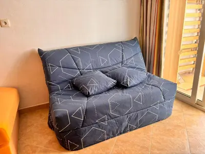 a black couch with pillows on it in a room at Les jardins de la mer marine de Bravone in Linguizzetta