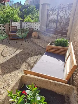 a patio with a bed and two chairs and plants at Villa avec vue panoramique sur les montagnes in Corscia
