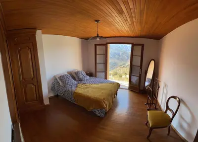 a bedroom with a bed and a large window at Villa avec vue panoramique sur les montagnes in Corscia