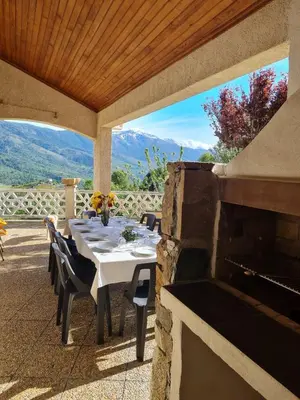 a table and chairs on a patio with a fireplace at Villa avec vue panoramique sur les montagnes in Corscia