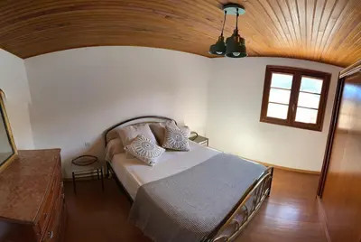 a bedroom with a bed with a wooden ceiling at Villa avec vue panoramique sur les montagnes in Corscia
