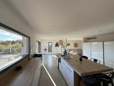 a kitchen with a table and a large window at Haut de Villa - Corsica in Lecci