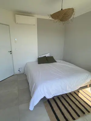 a bedroom with a large white bed with a rug at Haut de Villa - Corsica in Lecci