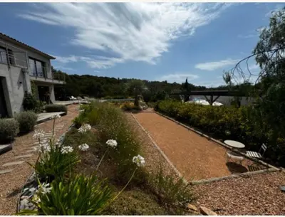 a garden with flowers and a building and a bridge at Haut de Villa - Corsica in Lecci