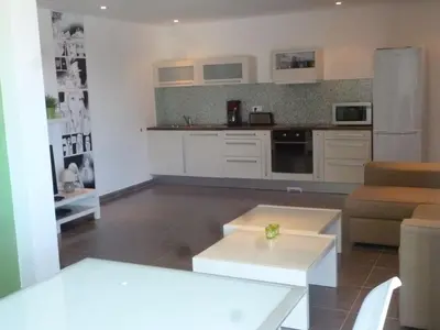 a kitchen with white cabinets and a table in a room at Maison au calme avec vue magnifique in Sari Solenzara