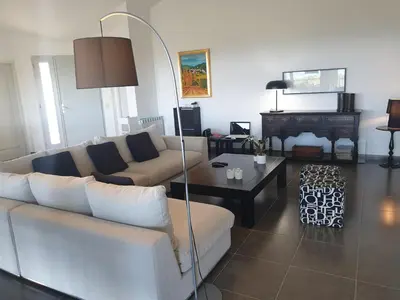 a living room with a couch and a table at Maison au calme avec vue magnifique in Sari Solenzara