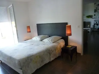a bedroom with a large bed with two lamps at Maison au calme avec vue magnifique in Sari Solenzara