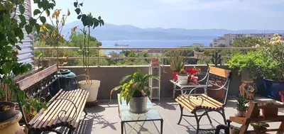 a balcony with chairs and tables and a view of the water at T3 vue mer proche plage in Ajaccio