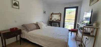 a bedroom with a bed and a television and a window at T3 vue mer proche plage in Ajaccio