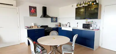 a kitchen with blue cabinets and a table with chairs at T3 vue mer proche plage in Ajaccio