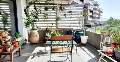 a balcony filled with lots of plants and chairs at T3 vue mer proche plage in Ajaccio