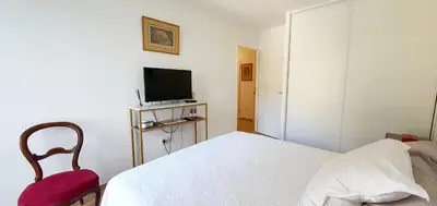 a bedroom with a bed and a tv and a chair at T3 vue mer proche plage in Ajaccio