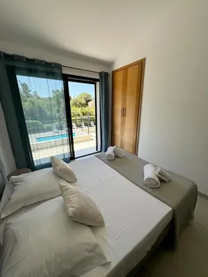a bedroom with a large bed with a large window at Villa - Porto-Vecchio - Piscine privée in Porto-Vecchio