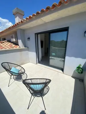 a patio with two chairs on a house at Villa - Porto-Vecchio - Piscine privée in Porto-Vecchio
