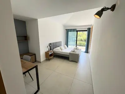 a living room with a couch and a table at Villa - Porto-Vecchio - Piscine privée in Porto-Vecchio