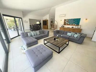 a large living room with couches and a table at Villa - Porto-Vecchio - Piscine privée in Porto-Vecchio