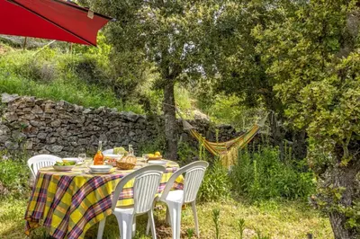 a table with white chairs and a table with food on it at Casa Di Babbo in Olmi-Cappella