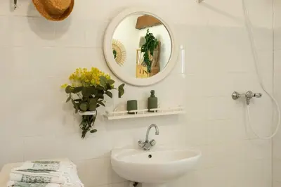 a white bathroom with a sink and a mirror at Casa Di Babbo in Olmi-Cappella