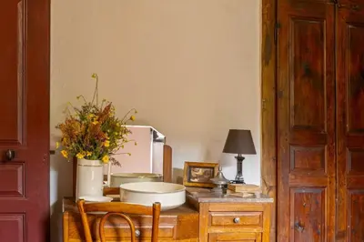a kitchen with a table with a microwave and a vase of flowers at Casa Di Babbo in Olmi-Cappella