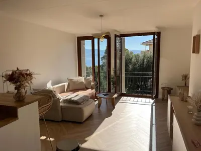 a living room with a couch and large windows at Charmant appartement T2 hypercentre à Ajaccio in Ajaccio