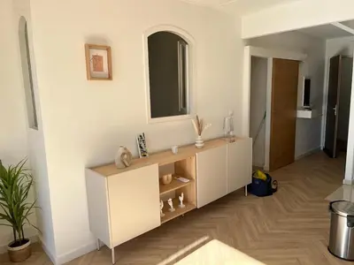 a living room with a white cabinet and a mirror at Charmant appartement T2 hypercentre à Ajaccio in Ajaccio