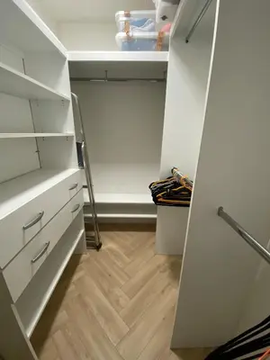 a small kitchen with white cabinets and a wooden floor at Charmant appartement T2 hypercentre à Ajaccio in Ajaccio