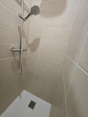 a shower with a shower head in a bathroom at New Superbe F2 refait à neuf tout confort avec piscine et mer à pied in Serra-di-Ferro
