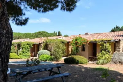 a house with a picnic table in front of it at New Superbe F2 refait à neuf tout confort avec piscine et mer à pied in Serra-di-Ferro