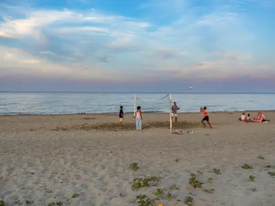 a group of people playing volleyball on the beach at Camping Domaine d'Anghione in Castellare-di-Casinca