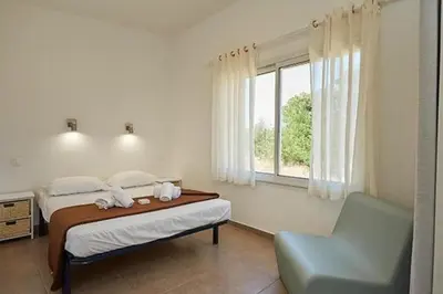 a bedroom with a bed and a chair and a window at Camping Domaine d'Anghione in Castellare-di-Casinca