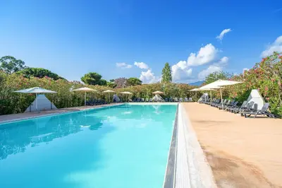 a swimming pool with chairs and umbrellas at Camping Domaine d'Anghione in Castellare-di-Casinca