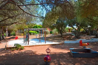 a park with a playground with a swing set at Villa 4 à 5 pers T2 climatisée & wifi résidence piscine et mer à pied in Serra-di-Ferro