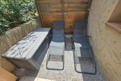 a pair of benches sitting next to a building at Villa 4 à 5 pers T2 climatisée & wifi résidence piscine et mer à pied in Serra-di-Ferro