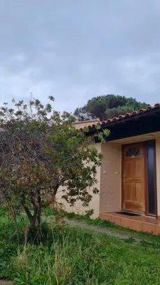 a house with a wooden door on the side of it at Villa 4 à 5 pers T2 climatisée & wifi résidence piscine et mer à pied in Serra-di-Ferro
