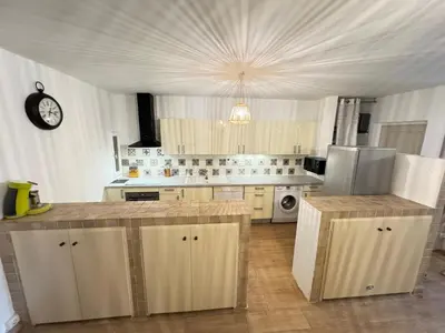 a kitchen with white cabinets and a clock on the ceiling at Fiori di sperenza in Coggia