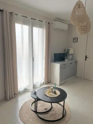 a living room with a coffee table in front of windows at Charmant T2 lumineux avec terrasse in Propriano