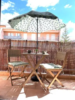 a table and chairs with an umbrella on a patio at Charmant T2 lumineux avec terrasse in Propriano