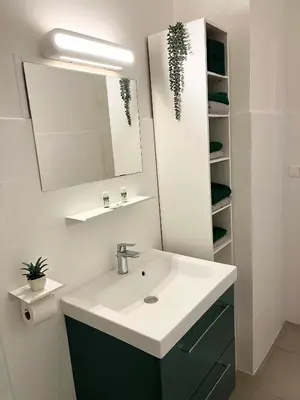 a bathroom with a sink and a mirror at Charmant T2 lumineux avec terrasse in Propriano