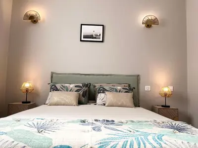 a bedroom with a large bed with two lamps at Charmant T2 lumineux avec terrasse in Propriano
