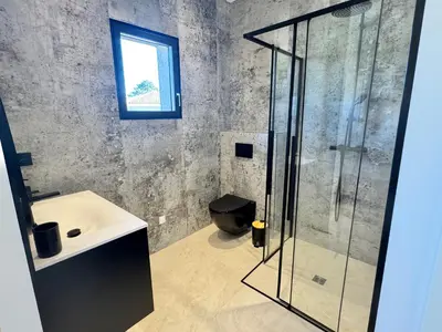 a bathroom with a glass shower and a sink at Villa Porto-Vecchio avec piscine in Lecci