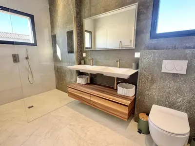 a bathroom with a sink and a toilet and a mirror at Villa Porto-Vecchio avec piscine in Lecci